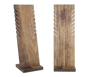 May include: Two wooden jewelry display stands with slots for necklaces and earrings. The stands are brown and have a natural wood finish.