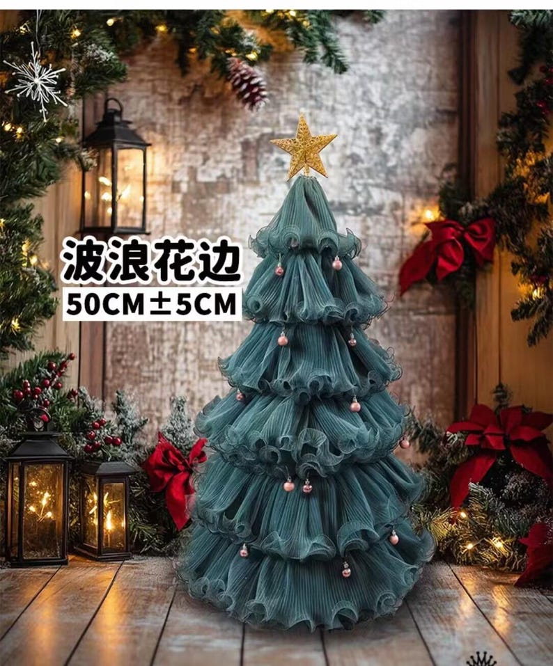 Peut inclure: Un sapin de No&euml;l en tissu vert d'eau avec une &eacute;toile dor&eacute;e au sommet et de petites d&eacute;corations roses. L'arbre mesure environ 50 cm de haut, avec le texte "波浪花边" et "50CM&plusmn;5CM" visible. Il est d&eacute;cor&eacute; d'un design &agrave; volants.