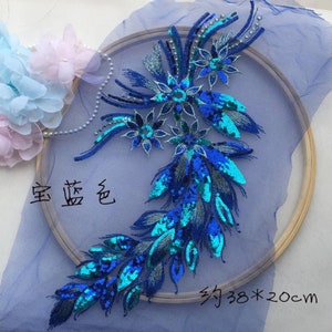 Peut inclure: Une applique de sequins bleu et vert avec un motif floral. L'applique mesure environ 38 cm sur 20 cm.