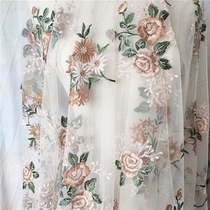 May include: White sheer fabric with embroidered floral designs in shades of brown, green, and white.