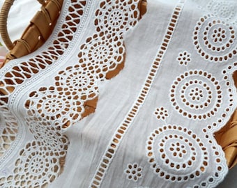 May include: White cotton lace trim with a scalloped edge and a delicate pattern of circles and flowers.