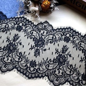 May include: Black lace trim with a scalloped edge and floral pattern.