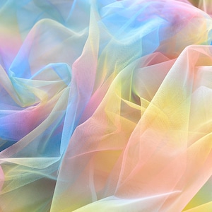 May include: A rainbow ombre tulle fabric with a soft, delicate texture. The fabric is sheer and has a gradient of colors, starting with light blue and transitioning to yellow and pink.