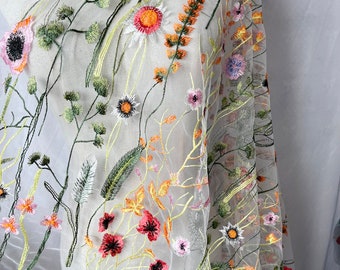 May include: White sheer fabric with embroidered floral designs in shades of pink, orange, yellow, and green.