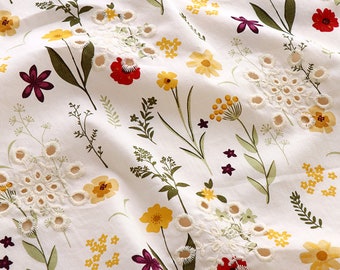 May include: White fabric with a floral pattern featuring yellow, red, and purple flowers. The flowers are embroidered with white thread and have a delicate, vintage aesthetic.