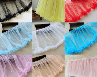 Può includere: Assortimento di passamanerie in tulle con decorazioni di perle in vari colori, tra cui nero, giallo, rosso, blu, bianco, rosa e pesca. Le passamanerie hanno un bordo arricciato e sono perfette per aggiungere un tocco di eleganza a qualsiasi progetto.