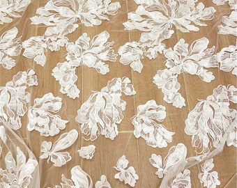 May include: White floral lace fabric with a delicate, intricate design. The lace features large, stylized flowers with a raised texture.