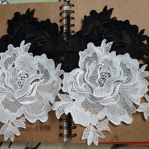Pode incluir: Renda branca e preta com um design floral. A renda é delicada e intrincada, com um efeito 3D em relevo. A renda é perfeita para adicionar um toque de elegância a qualquer projeto.