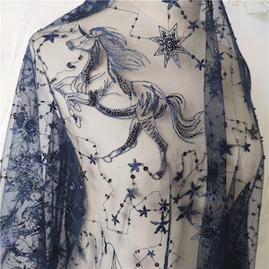 May include: Navy blue sheer fabric with embroidered stars and a unicorn design. The fabric is embellished with sequins and beads.