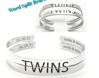 Könnte beinhalten: Zwei silberne Armbänder mit dem Wort "TWINS", das zwischen ihnen aufgeteilt ist. Die Armbänder sind mit dem Datum "06.08.91" und den Namen "Jackie & Jenny" graviert.