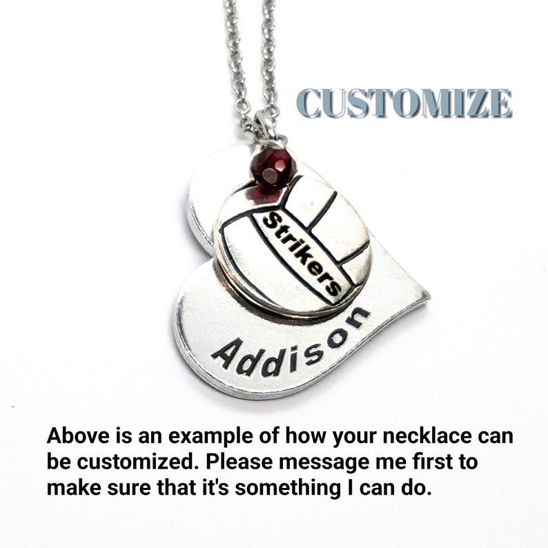 May include: Silver heart necklace with a volleyball charm and the name "Addison" engraved on it. The volleyball charm has the word "Strikers" written on it. The necklace has a red gemstone accent.