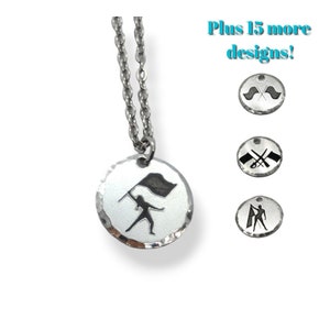 May include: Silver necklace with a round pendant featuring a silhouette of a color guard performer holding a flag. The pendant has a hammered texture.  Plus 15 more designs!