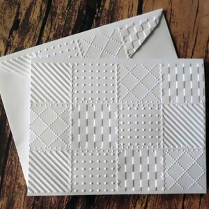 May include: White card stock with a variety of embossed patterns in a grid layout. The patterns include dots, stripes, squares, and diamonds.