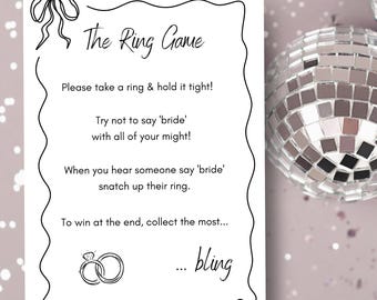 May include: A printable game card with instructions for a ring game. The card has a black and white illustration of a ring and the text "The Ring Game". The text on the card reads: "Please take a ring & hold it tight! Try not to say 'bride' with all of your might! When you hear someone say 'bride' snatch up their ring. To win at the end, collect the most... ...bling"