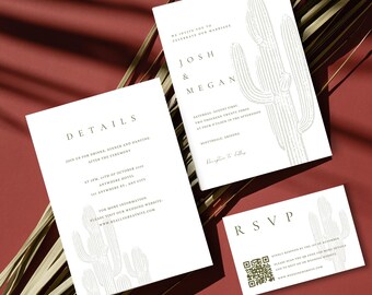 May include: A collection of white wedding stationery featuring a cactus design. The set includes an invitation, details card, and RSVP card. The invitation displays the names "Josh & Megan" and event details. The cards are arranged on a red surface.