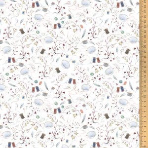 Op de afbeelding: Witte stof met een herhaald patroon van naaibenodigdheden. Het ontwerp omvat klosjes garen, scharen, vingerhoeden, veren en bloemtakken. Een houten liniaal is zichtbaar aan de rechterkant.