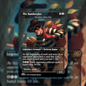 May include: A trading card featuring "The Hamburglar," a skeleton rogue character. The card depicts a cartoon burglar in a black and white striped shirt, holding a hamburger. The card has a black border and includes game text and a power/toughness of 1/2.
