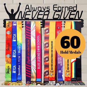 May include: Black metal medal display with the words "Always Earned, Never Given." It holds 60 medals, with colorful ribbons from various events. A silhouette of a person with arms raised is at the top.