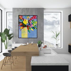 May include: A colorful abstract painting of a bouquet of flowers in a yellow vase against a blue background. The painting is hanging on a wall in a modern kitchen with a white countertop and black cabinets.