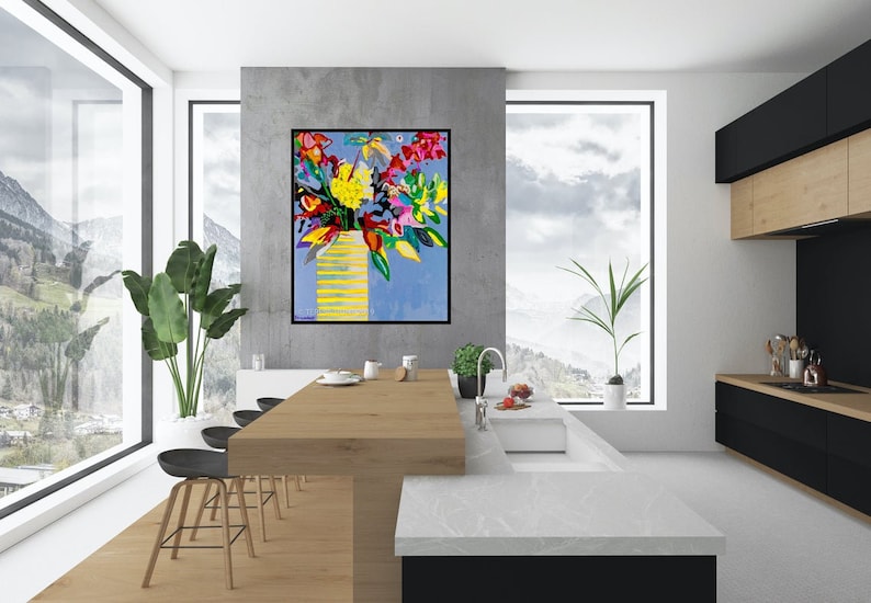 May include: A colorful abstract painting of a bouquet of flowers in a yellow vase against a blue background. The painting is hanging on a wall in a modern kitchen with a white countertop and black cabinets.