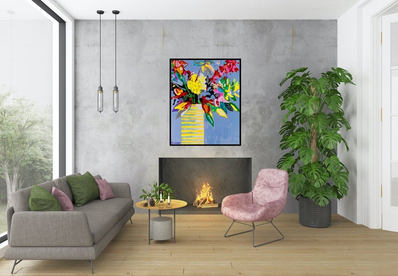May include: A colorful abstract painting of a bouquet of flowers in a yellow vase against a blue background. The painting is framed and hanging on a wall in a living room setting.