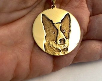May include: A gold-toned circular pendant necklace featuring a detailed laser-engraved portrait of a dog with pointed ears and a distinct facial marking. The pendant is suspended from a delicate gold-toned chain link necklace.