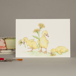 Cartão de felicitações com patinhos fofos e dentes-de-leão colhidos à mão, cartão de felicitações para a primavera.