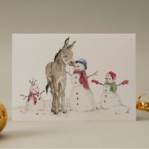 Âne curieux // âne effronté qui vole une carotte / carte de Noël / festif / voeux de fin d'année / bonhomme de neige / neige / drôle / mignon / petit