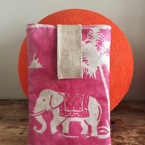 Puede incluir: Funda de teléfono de tela rosa con un diseño de elefante blanco y una correa de tela beige.
