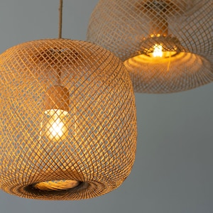 Pu&ograve; includere: Due lampade a sospensione in bamb&ugrave; intrecciato con lampadine a luce bianca calda. Le lampade sono appese al soffitto e sono realizzate in un materiale intrecciato naturale.