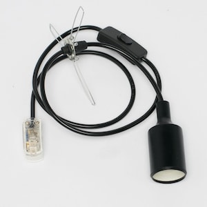 May include: Black electrical cord with an inline on/off switch and a black lamp socket. The cord is attached to a clear plug with two prongs.