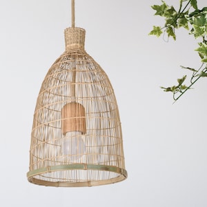 Puede incluir: Una lámpara colgante de tejido natural con una bombilla en su interior. La lámpara está hecha de bambú tejido y tiene un color natural y terroso.