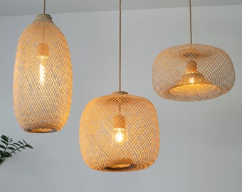 May include: Three woven pendant lights with a natural beige color. The lights are hanging from the ceiling and have a warm, inviting glow.