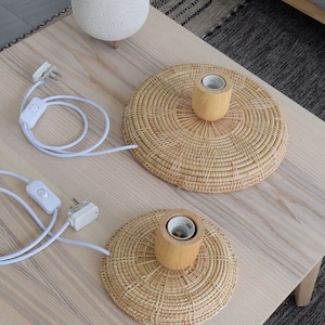 May include: Two woven rattan table lamps with wooden bases and white cords with inline switches and plugs. *Plugs may differ based on region*