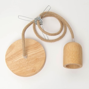 以下が含まれることがあります： ナチュラルな仕上げの木製ペンダントライト。照明器具はジュートロープで吊り下げられており、シンプルで円筒形のデザインです。