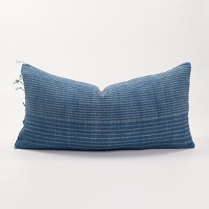 May include: A blue and white striped throw pillow with a frayed edge.