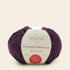 May include: A ball of purple cashmere merino silk yarn with a white label that reads "Sirdar West Yorkshire Est. 1880 Cashmere Merino Silk Double Knitting 50g* *116 m/127 yds approx West Yorkshire British Design, Expertise and Craftsmanship Trusted by Generations of Hand Knitters Est. 1880"