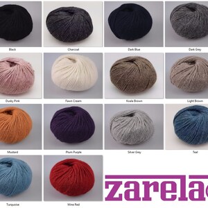 May include: A collection of 16 yarn skeins in various colors, including black, charcoal, dark blue, dark grey, dusty pink, fawn cream, koala brown, light brown, mustard, plum purple, silver grey, teal, turquoise, and wine red. The yarn is arranged in a grid pattern with the brand name "zarela" displayed at the bottom.