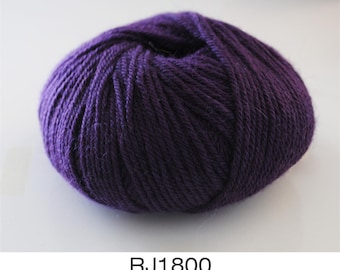 Puede incluir: Un ovillo de lana de color morado oscuro, listo para proyectos de tejido o ganchillo.