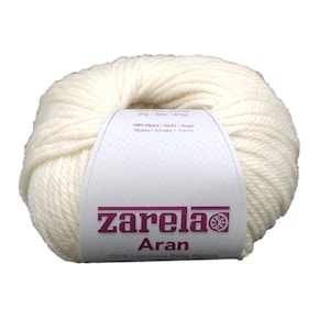 May include: A ball of white yarn labeled "zarela Aran 100% Luxurious Baby Alpaca". The label also includes the weight (50g), length (80m/87yd), and fiber content (100% Alpaca).