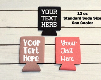 May include: Three 12 ounce standard soda size can coolers. One is black with white text that says "YOUR TEXT HERE". One is brown with white text that says "YOUR Text Here". One is pink with white text that says "Your Text Here".