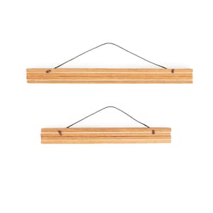 May include: Two wooden poster hangers with a natural wood grain finish. Each hanger consists of two wooden strips connected by a thin, dark string for hanging. The design is simple and minimalist, suitable for displaying artwork or posters.