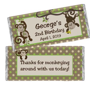 May include: Two chocolate bar wrappers with a monkey theme. One wrapper says "George's 2nd Birthday April 1, 2019" with monkey illustrations. The other says "Thanks for monkeying around with us today!" with a monkey illustration.