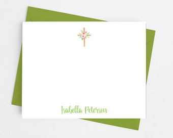 May include: A white card with a floral cross design and the name "Isabella Peterson" printed in green text.