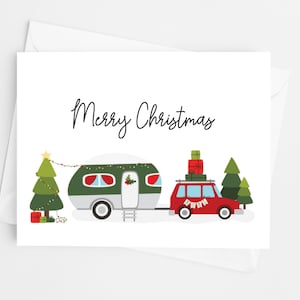 May include: A Christmas card featuring a red car towing a green and white camper. The car is loaded with gifts and the camper is decorated with lights. A Christmas tree and the words "Merry Christmas" are also featured.