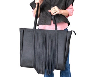 May include: A large black leather tote bag with a long fringe detail. The bag has a zipper closure and two top handles.