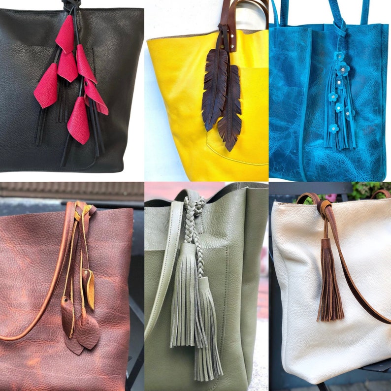 Op de afbeelding: Een verzameling leren tote bags in verschillende kleuren, elk versierd met unieke leren kwasten en decoratieve accenten. De tassen hebben verschillende handvatstijlen en texturen, die een reeks ontwerpen en vakmanschap laten zien.