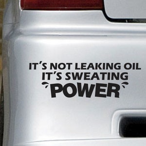 May include: A silver car bumper with a black vinyl sticker that reads "It's not leaking oil It's sweating power".