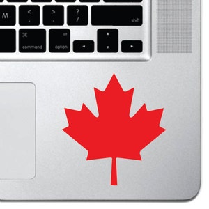 May include: A red maple leaf sticker on a silver laptop.