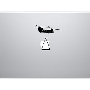 Może przedstawiać: Czarna sylwetka helikoptera z wiszącym pod nim siatką ładunkową, na białym tle.